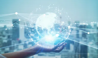 手のひらに浮かぶ地球とデジタルネットワークのイメージ