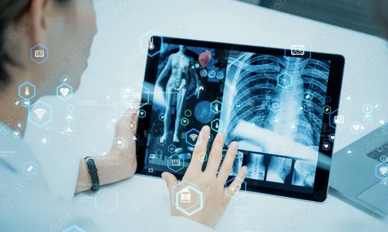 医師がタブレットで、人体の3DモデルとX線画像を分析している様子
